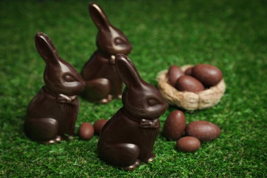 Chocolate bunnies and eggs on green grass. Easter celebration