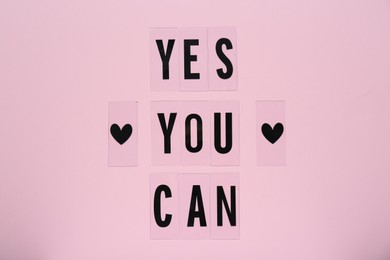 Photo of Phrase Yes You Can and hearts on pink background, top view. Motivational quote