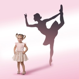 Cute little girl dreaming to be ballet dancer. Silhouette of woman behind kid's back