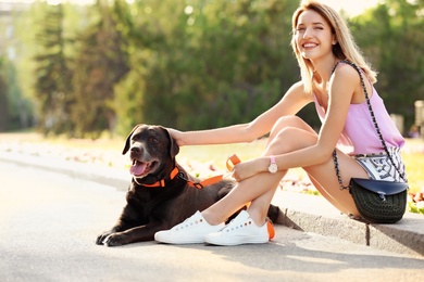 Photo of Cute brown labrador retriever with owner outdoors