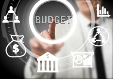 Image of Budget management. Businessman using virtual screen with financial icons, closeup