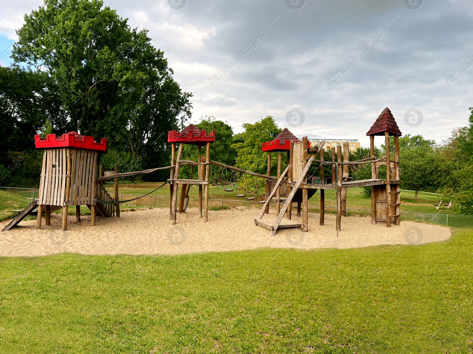 Photo of Beautiful wooden children's playground on sand outdoors