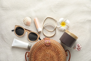 Photo of Flat lay composition with sun protection cosmetic products on sand, space for text