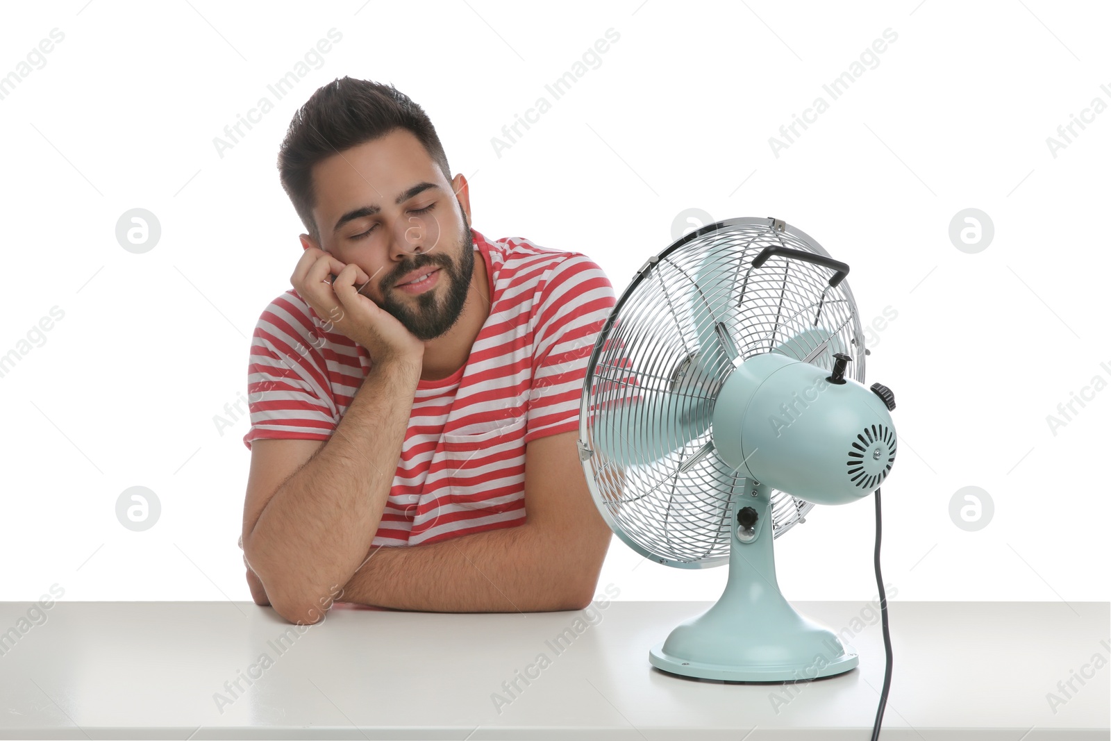 Photo of Man enjoying air flow from fan on white background. Summer heat