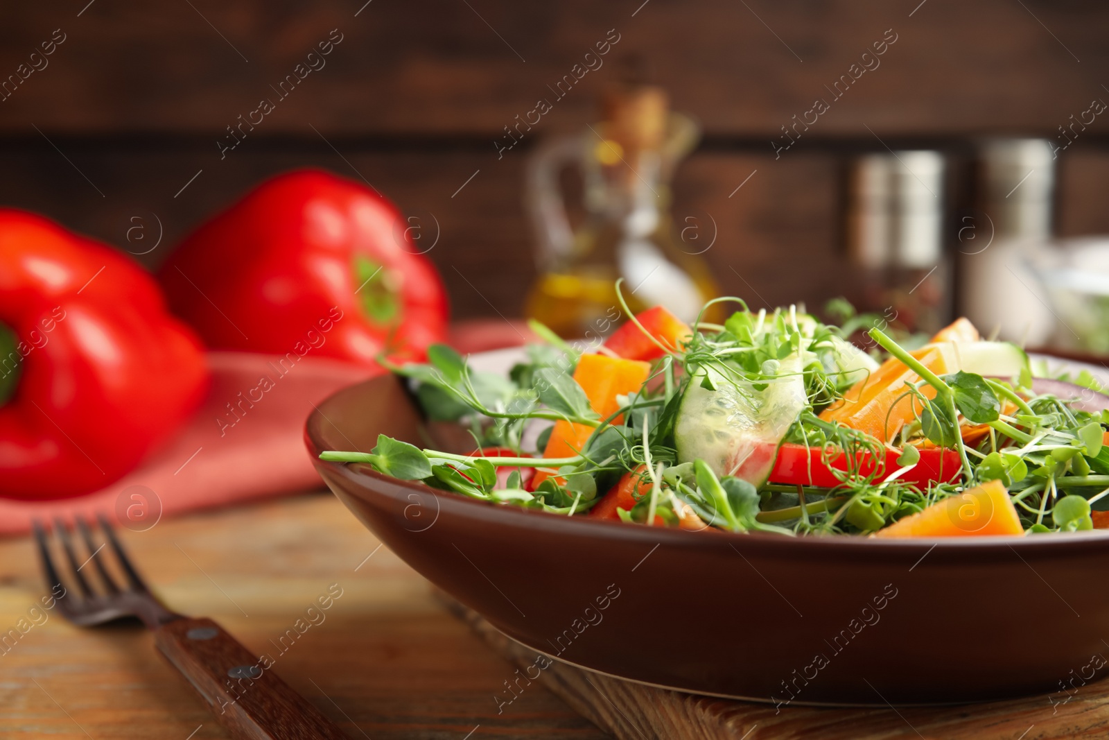 Photo of Delicious vegetable salad with microgreen served on wooden table, closeup