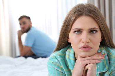 Young couple with relationship problems ignoring each other in bedroom