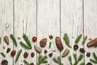 Photo of Flat lay composition with pinecones on white wooden background, space for text