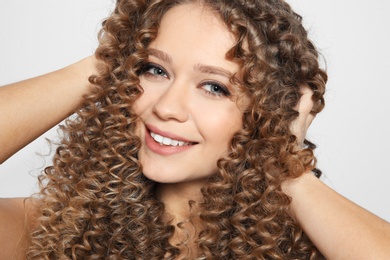Photo of Portrait of beautiful young woman with shiny wavy hair on color background, closeup
