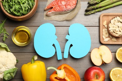 Photo of Flat lay composition with paper cutout of kidneys and different products on wooden table