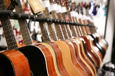 Row of different guitars in music store, closeup