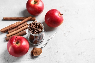 Photo of Fresh apples with cinnamon sticks and powder on table