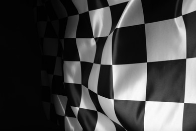 Photo of Checkered flag on black background, closeup view