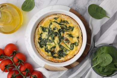 Photo of Delicious pie with spinach on white marble table, flat lay