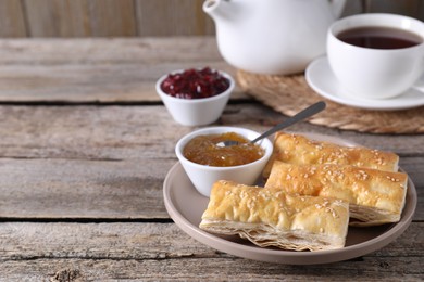 Photo of Delicious puff pastry served on wooden table, space for text