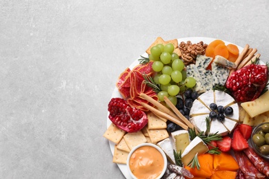 Assorted appetizers served on light grey table, top view. Space for text