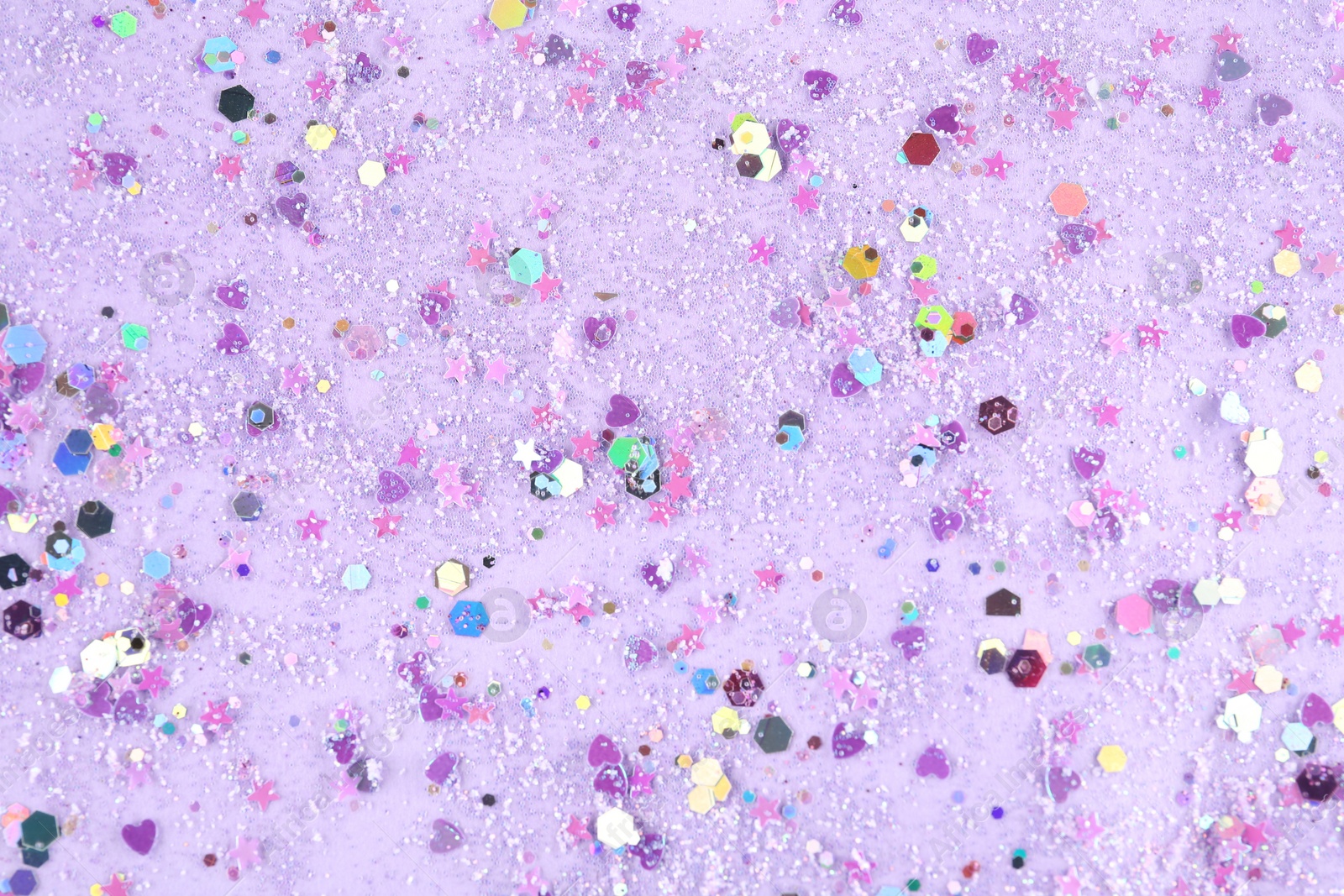 Photo of Shiny glitter on lilac background, top view