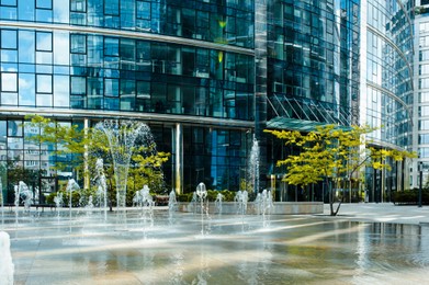 Photo of Beautiful fountains and trees near buildings in city