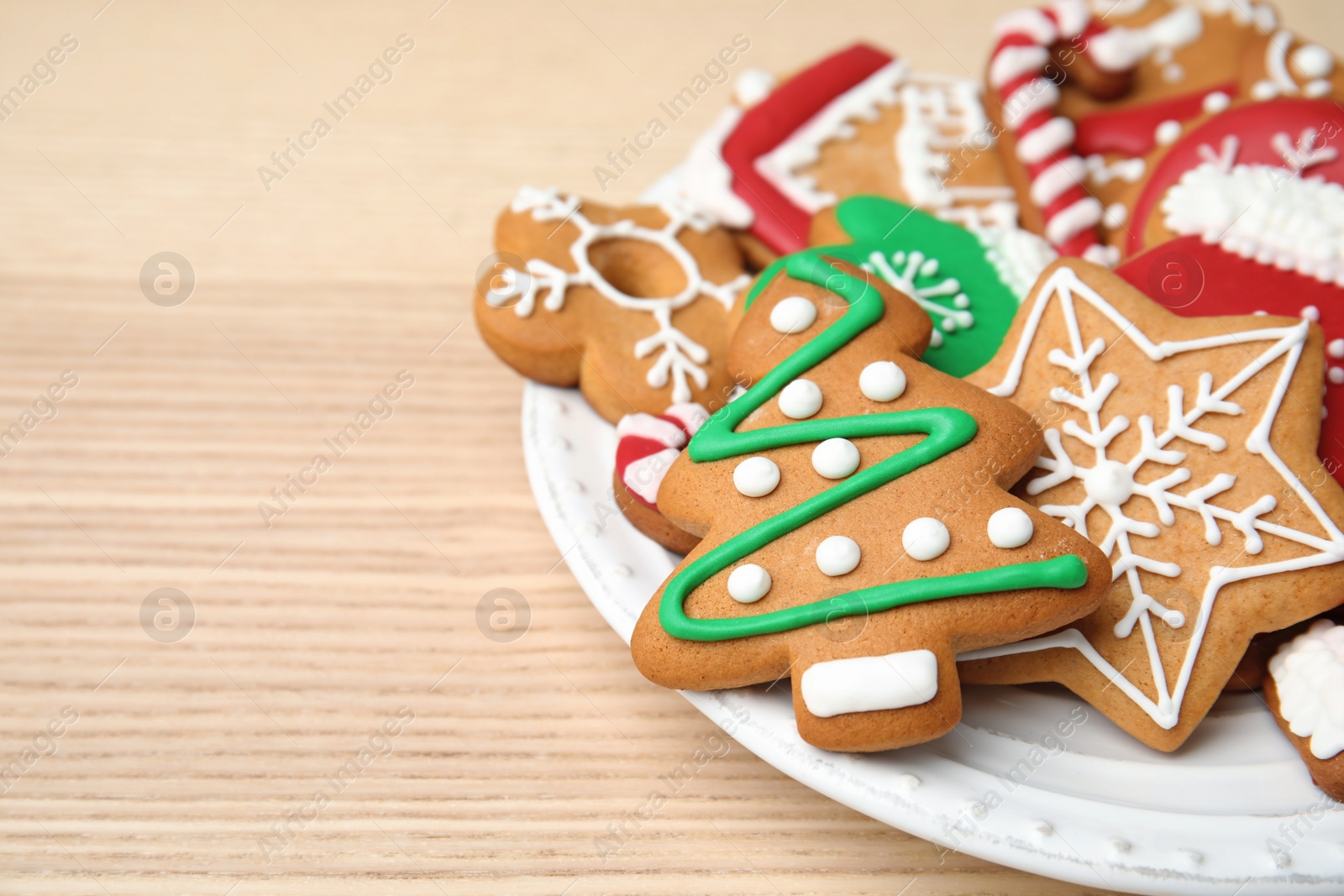 Photo of Plate with tasty homemade Christmas cookies on table, closeup