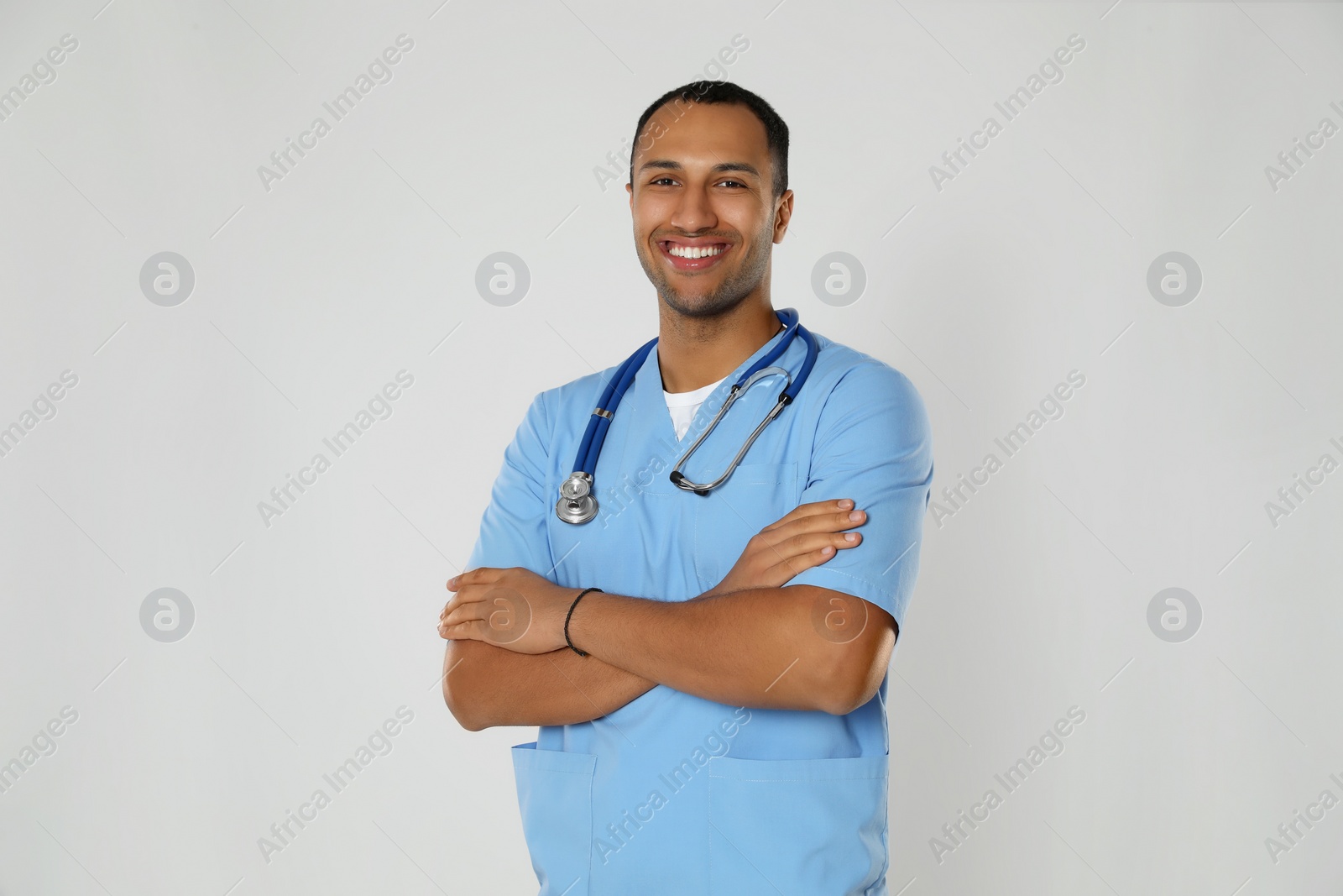 Photo of Doctor or medical assistant (male nurse) in uniform with stethoscope on light grey background