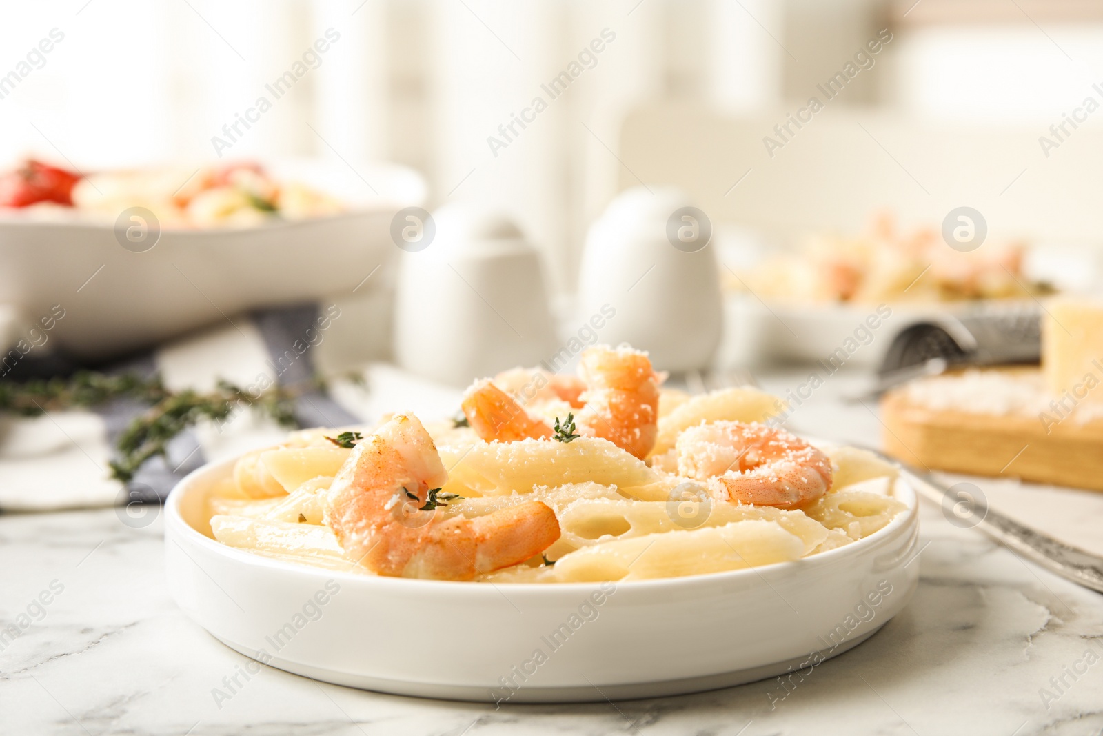 Photo of Delicious pasta with shrimps served on white marble table