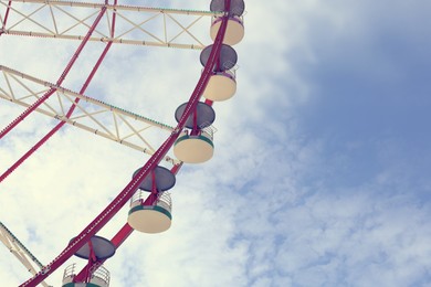 Image of Beautiful large Ferris wheel against blue sky, low angle view, space for text