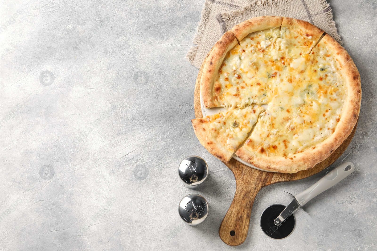 Photo of Delicious cheese pizza and cutter on light grey table, flat lay. Space for text