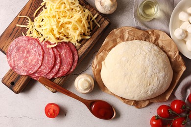 Photo of Pizza dough and products on gray textured table, flat lay