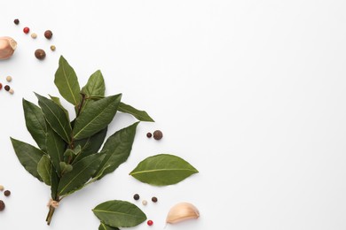 Aromatic bay leaves and spices on white background, flat lay. Space for text