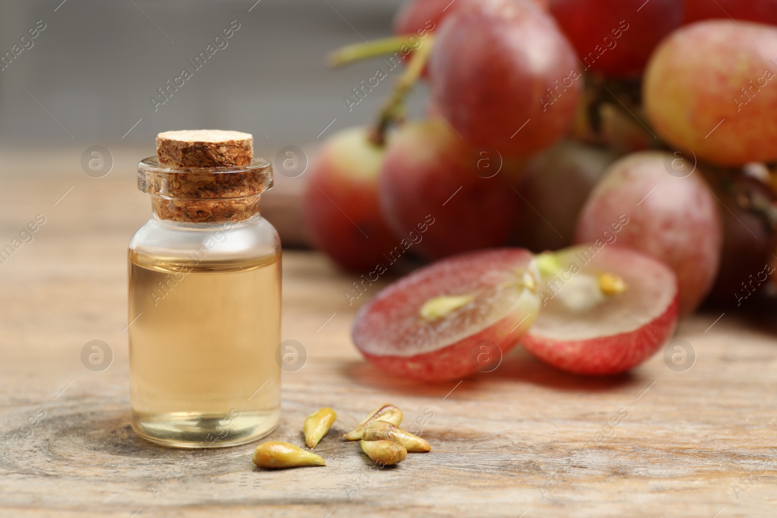 Photo of Natural grape seed oil on wooden table. Organic cosmetic