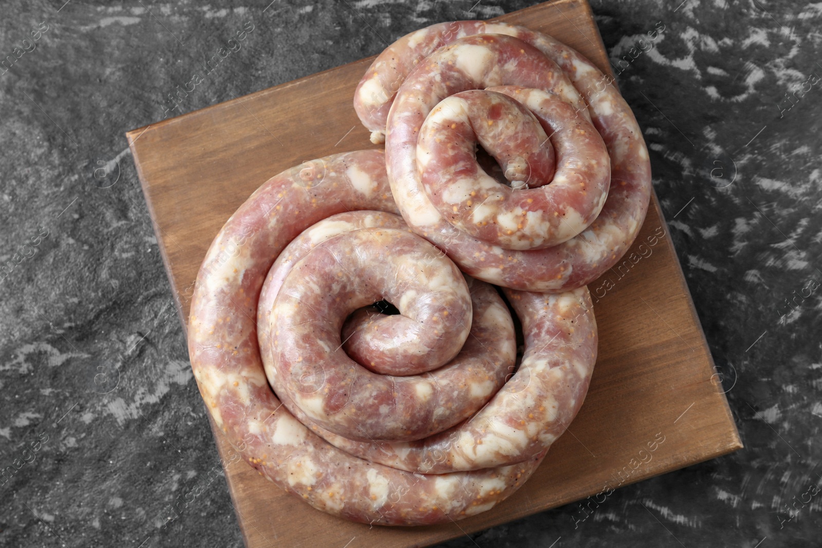 Photo of Raw homemade sausages on grey textured table, top view