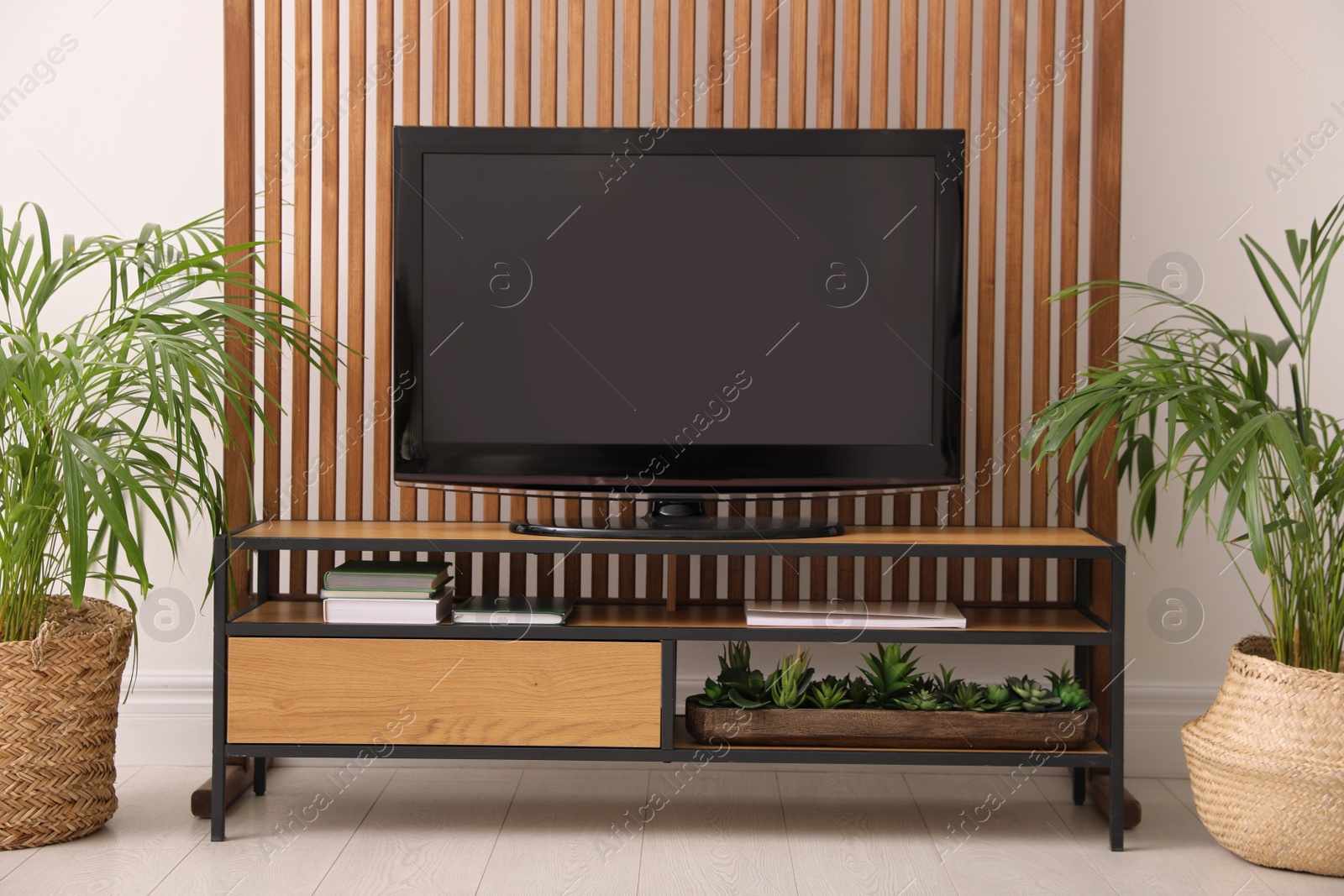 Photo of Elegant room interior with modern TV on cabinet and beautiful houseplants