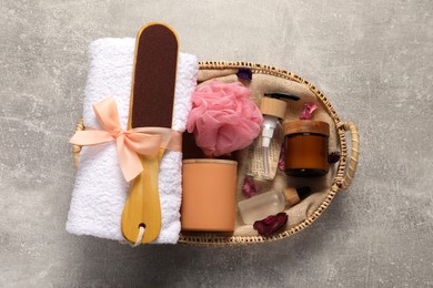 Photo of Spa gift set with different products in wicker basket on grey table, top view