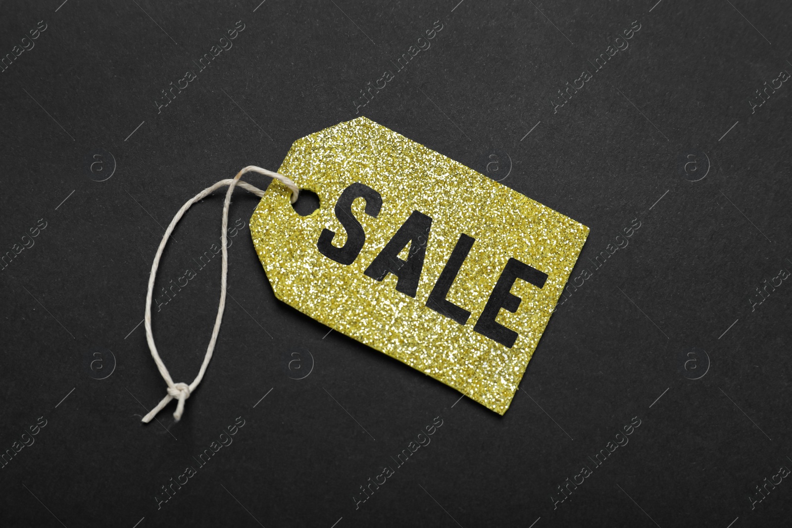 Photo of Sale golden tag on color background, top view. Black Friday