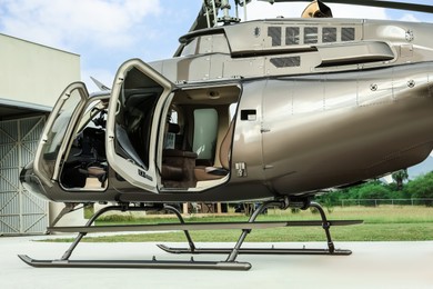 New helicopter with open cabin doors on helipad outdoors