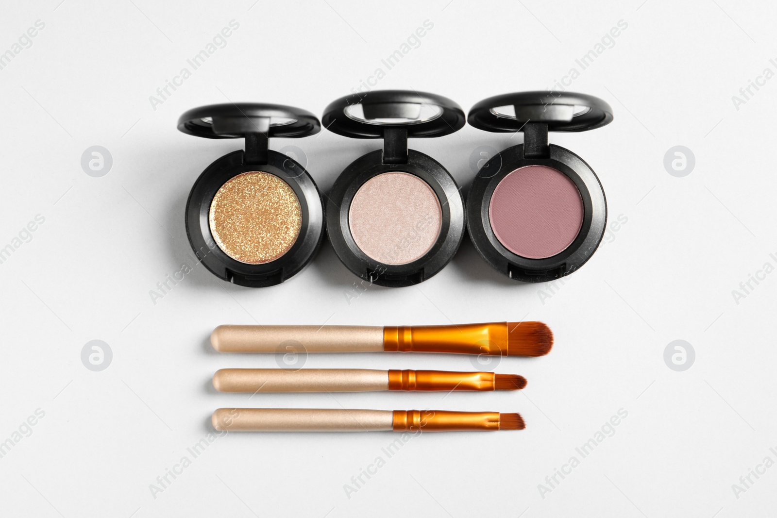 Photo of Different eye shadows and brushes on white background, flat lay. Decorative cosmetics