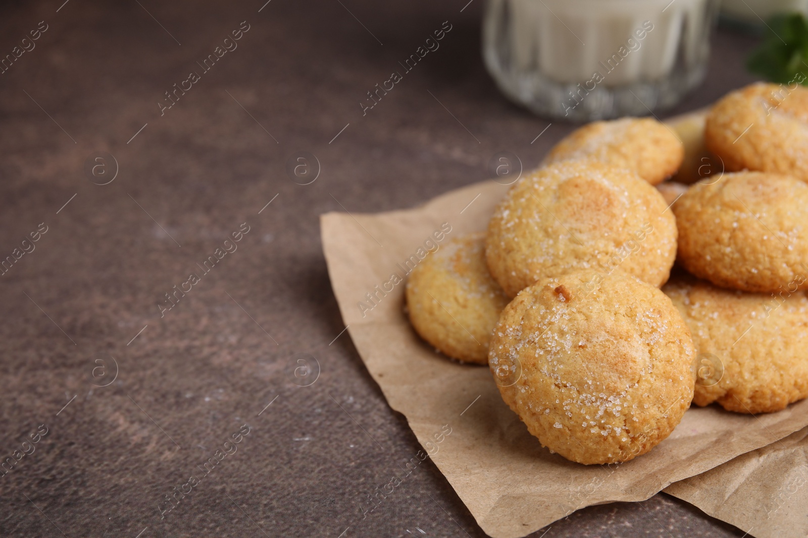 Photo of Tasty sweet sugar cookies on brown table, closeup. Space for text