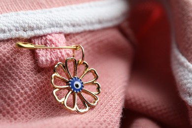 Photo of Evil eye safety pin on clothing, closeup
