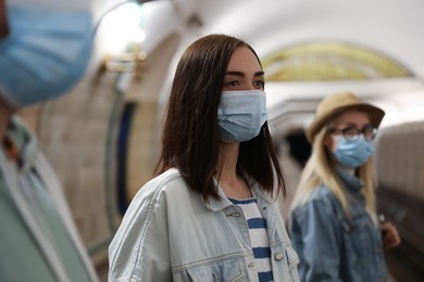 Photo of Young woman in protective mask at subway station. Public transport