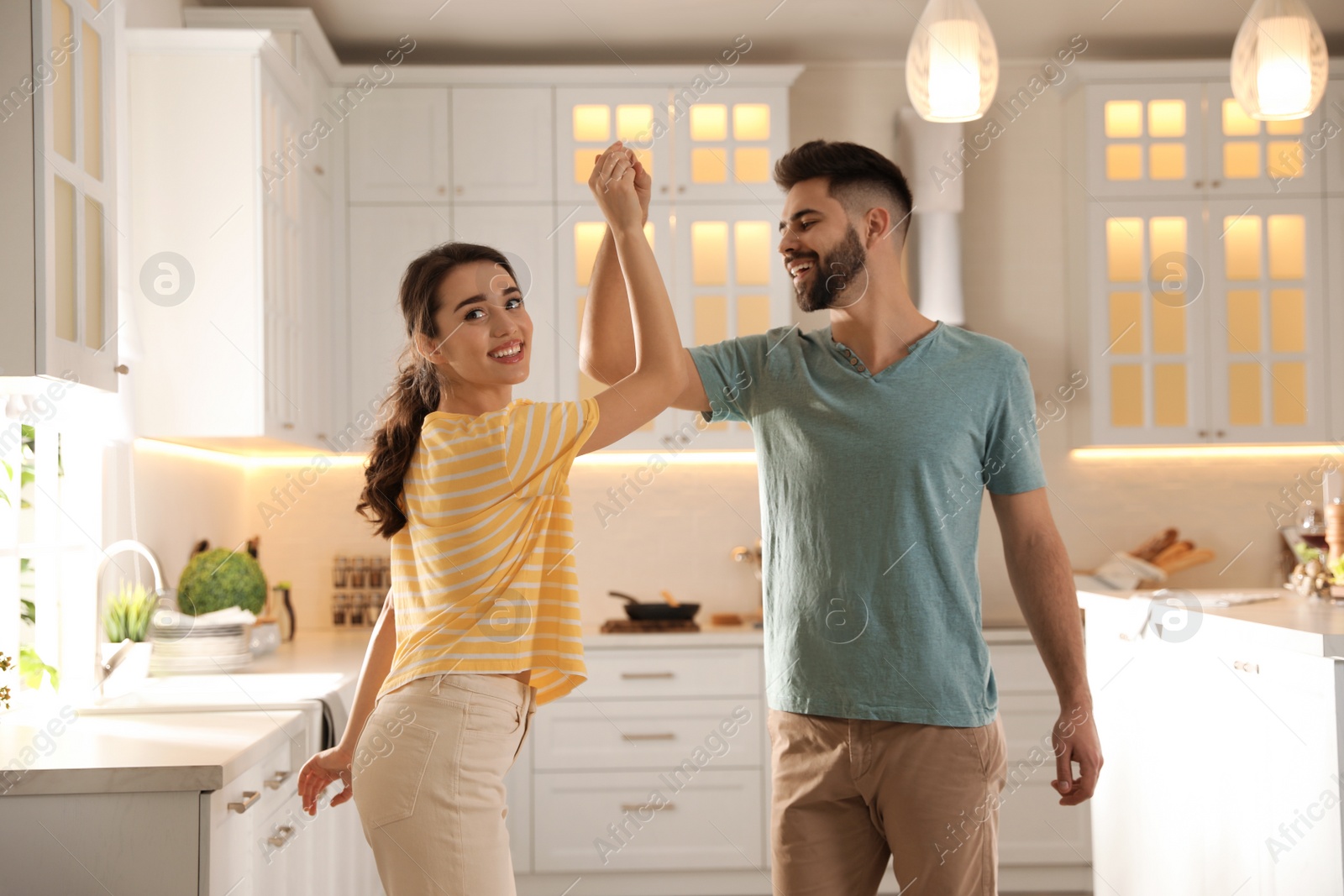 Photo of Lovely young couple dancing in kitchen. Cooking together