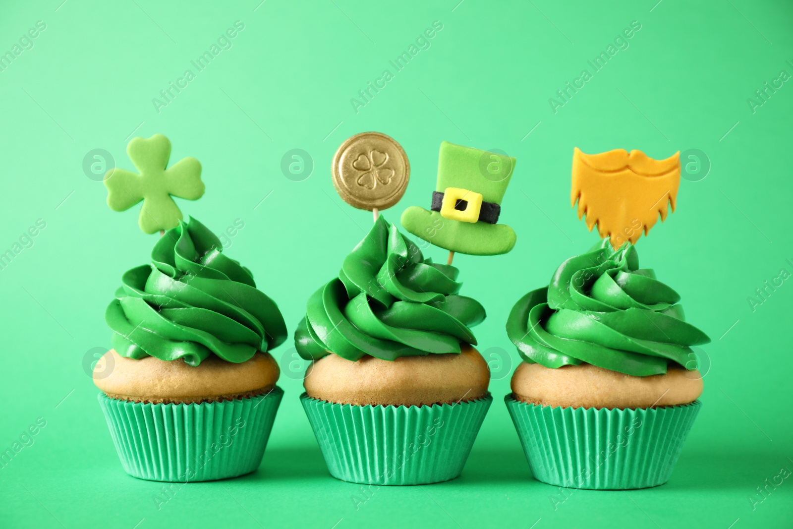 Photo of Decorated cupcakes on green background. St. Patrick's Day celebration