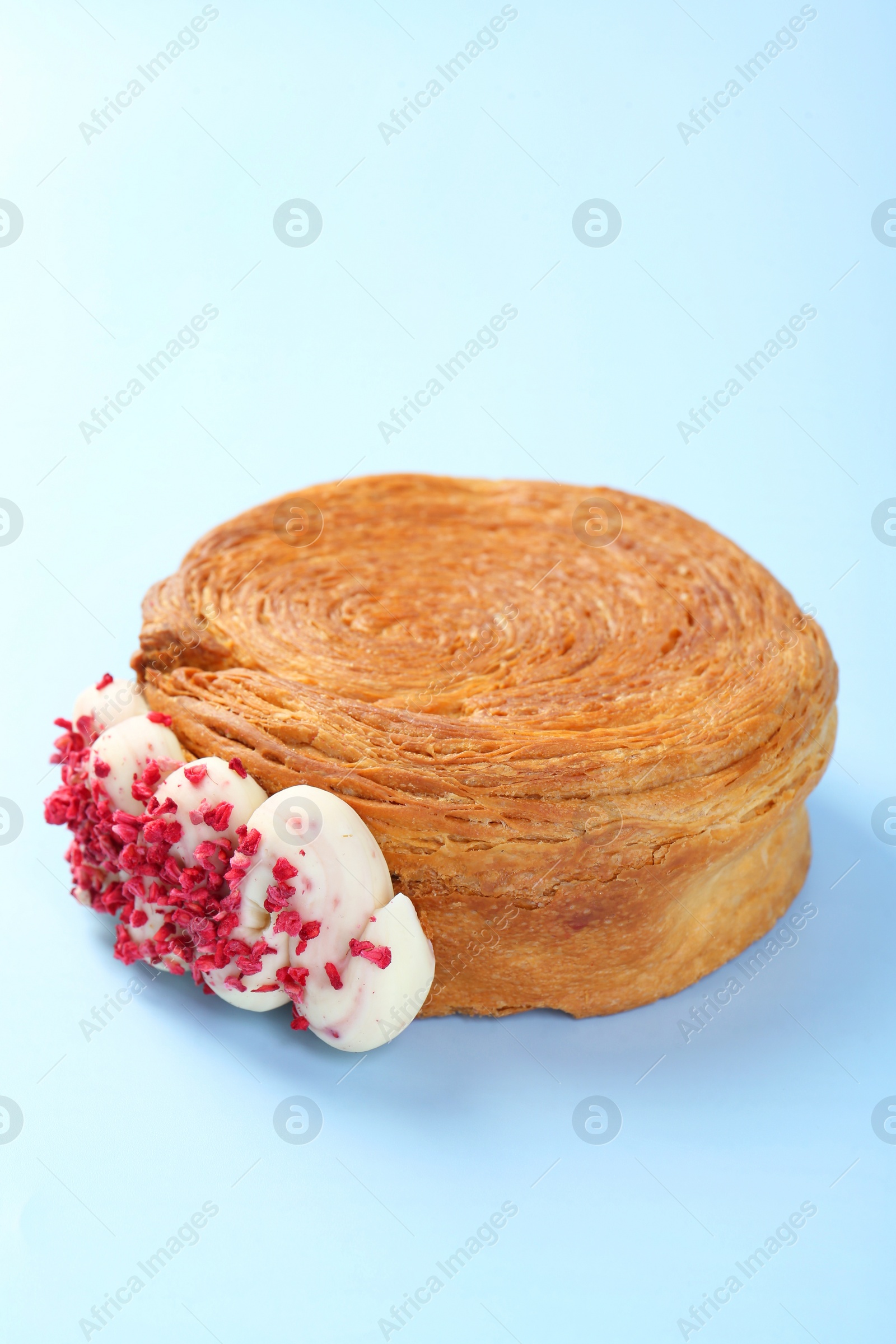 Photo of One supreme croissant with cream on light blue background. Tasty puff pastry