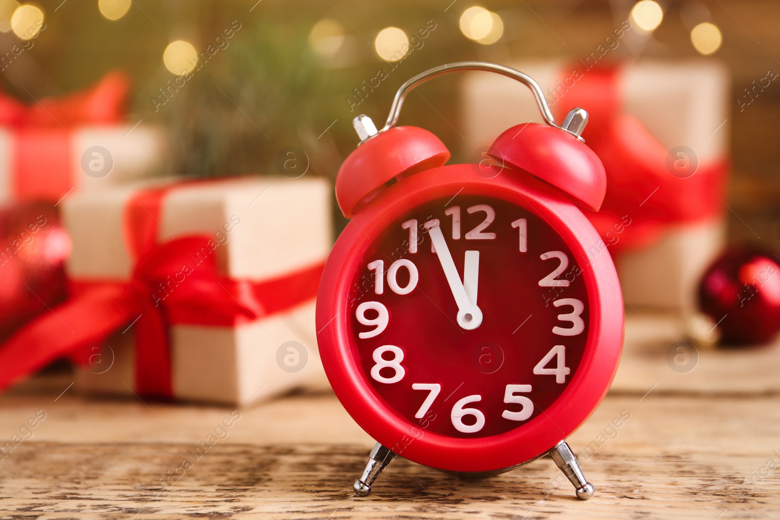 Photo of Beautiful composition with alarm clock and Christmas gifts on wooden table, space for text. Boxing day