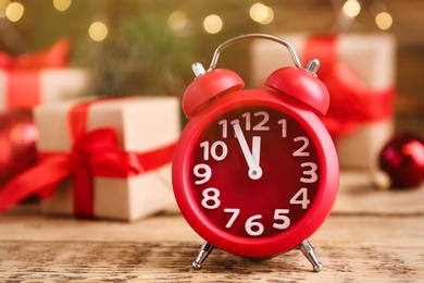 Beautiful composition with alarm clock and Christmas gifts on wooden table, space for text. Boxing day