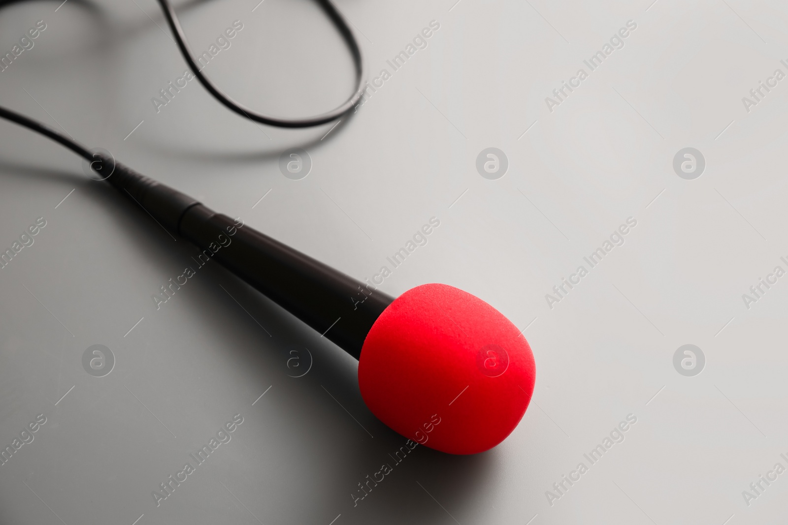 Photo of Microphone on light grey background. Journalist's work