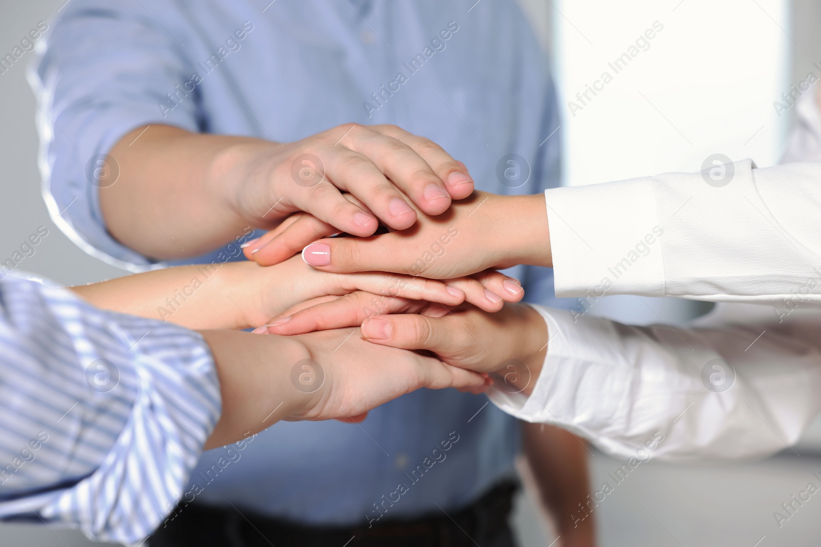 Photo of Group of people holding hands together indoors, closeup. Unity concept