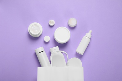 Photo of Flat lay composition with cosmetic products on violet background