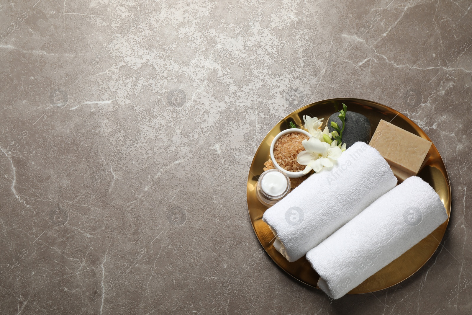 Photo of Tray with spa items on grey marble table, top view. Space for text