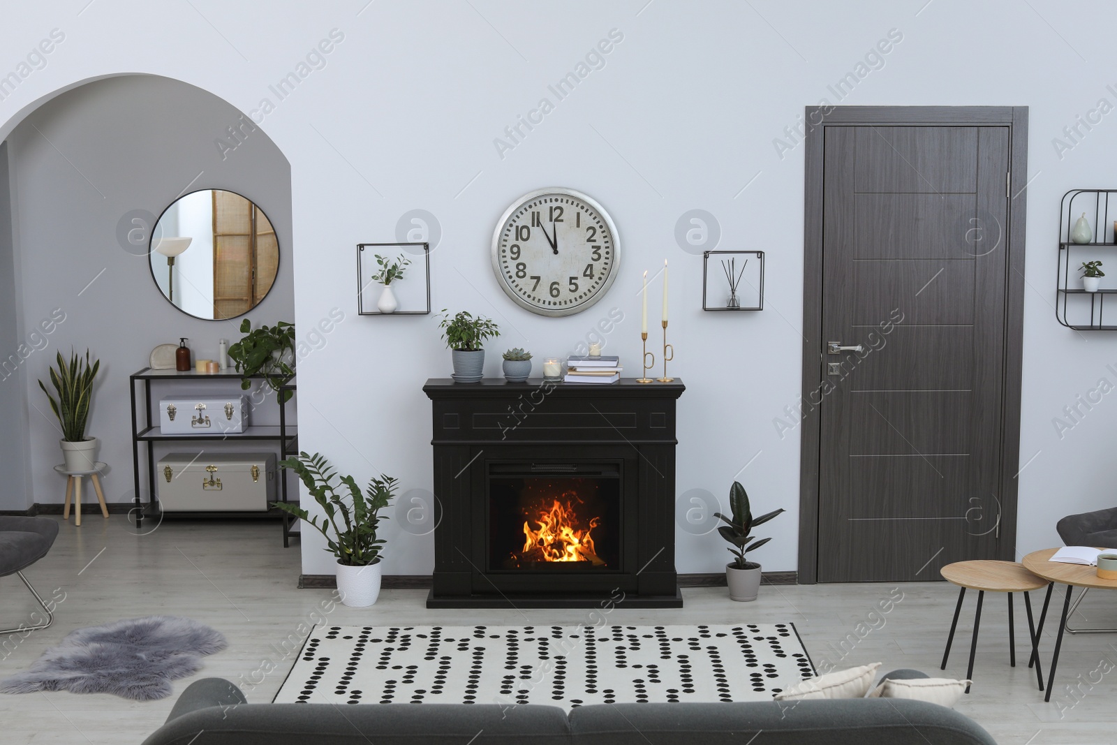 Photo of Stylish living room interior with fireplace and green plants