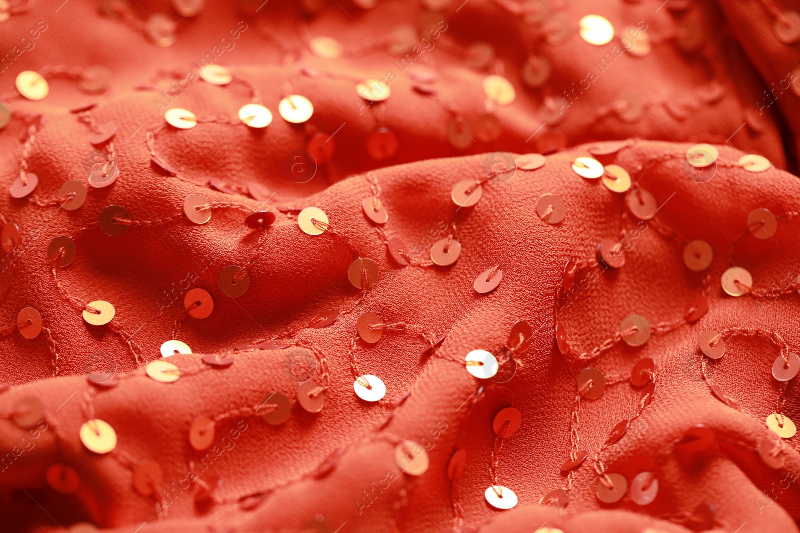 Photo of Beautiful red cloth with sequins as background, closeup