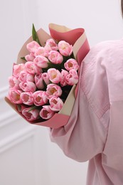 Woman with bouquet of beautiful fresh tulips on blurred background, closeup